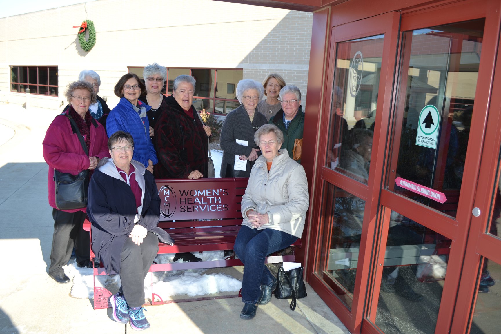 Auxiliary Members by the bench they donated