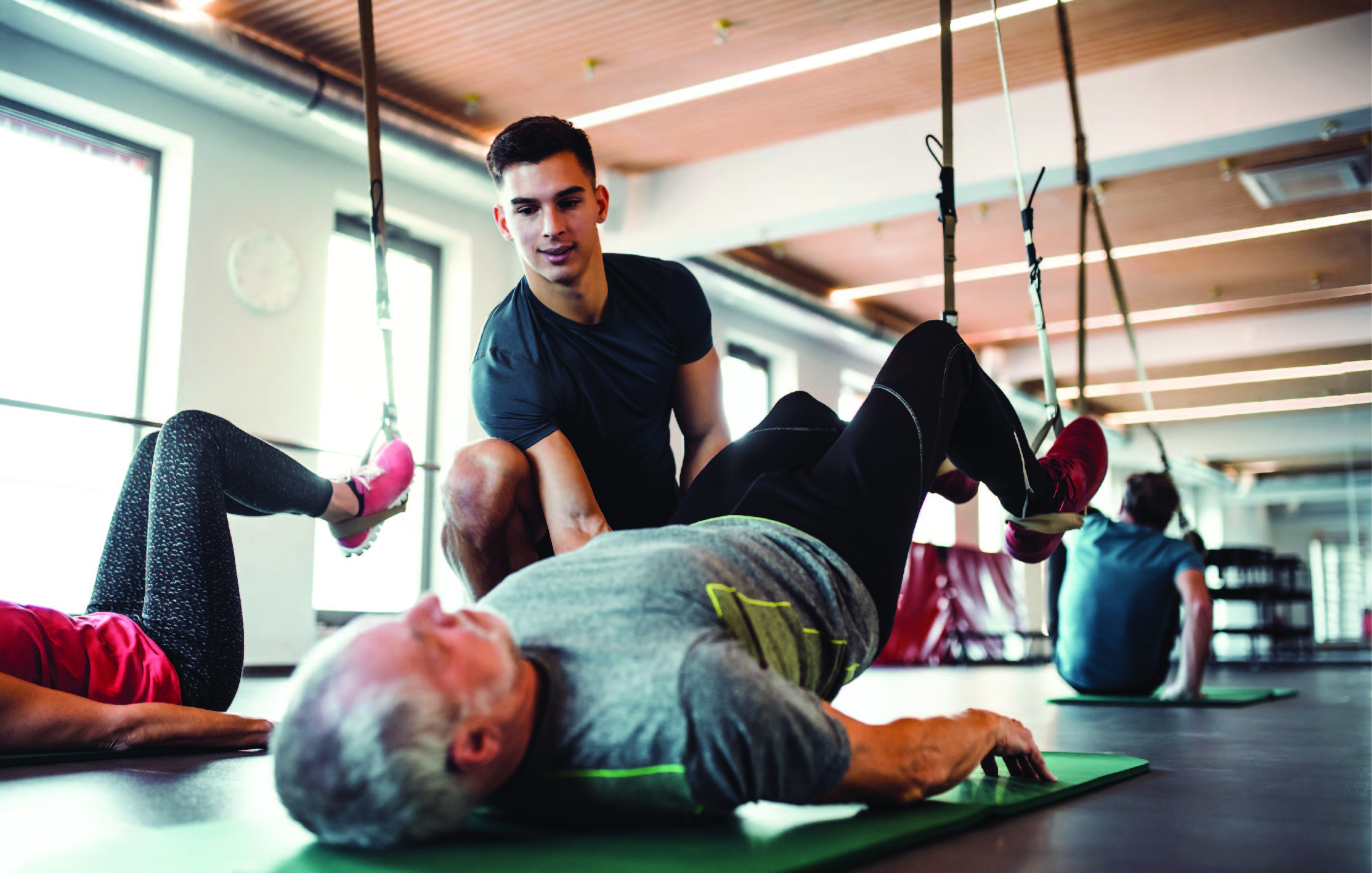 Trainer helping client with exercise